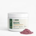 Dr. Strong Reds Superfood Powder tub with a pile of powder